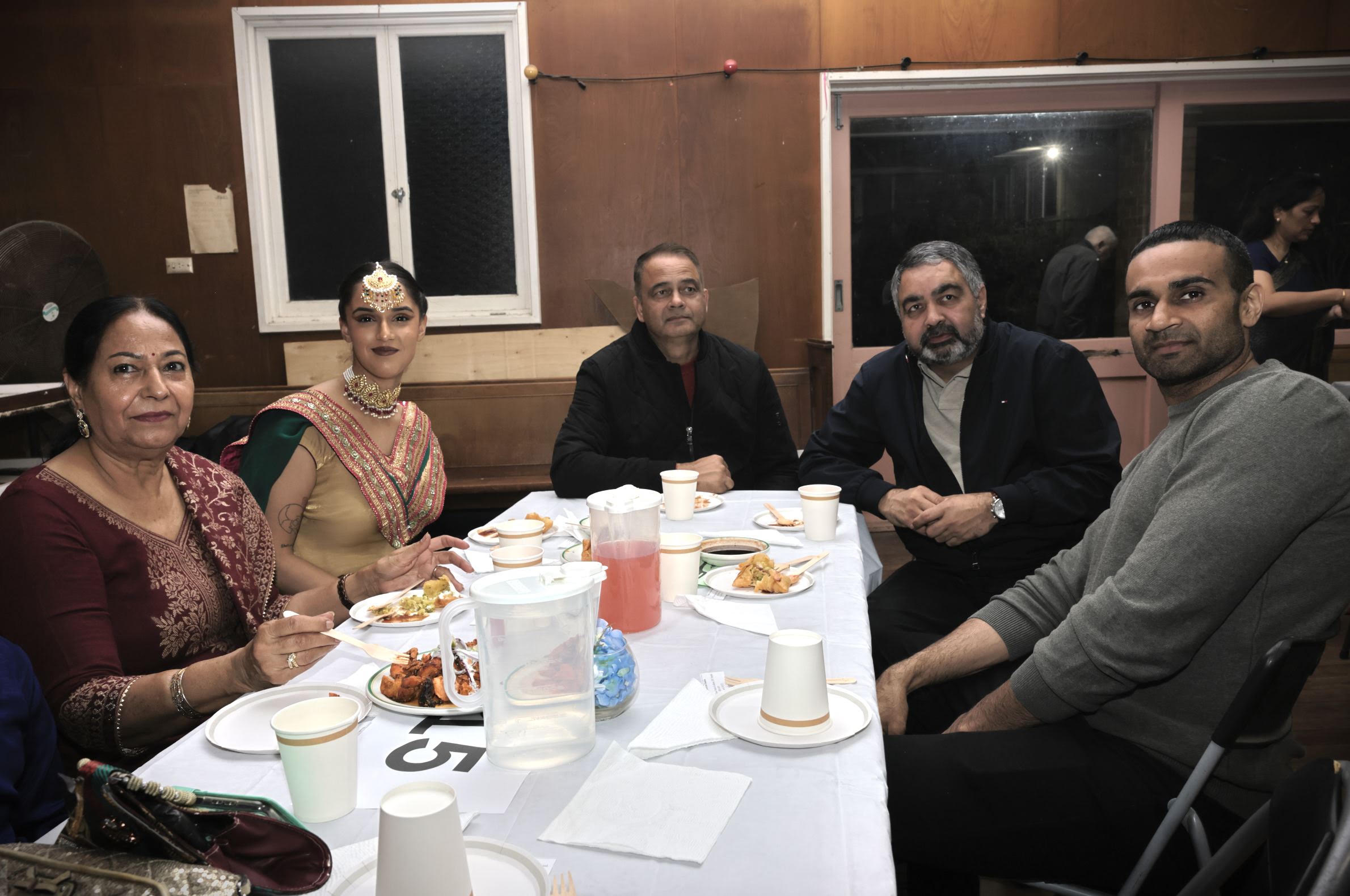 Guests in traditional dress enjoying dinner together